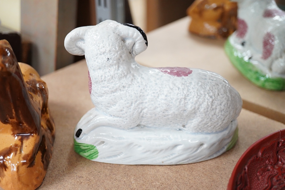 A Staffordshire Pearlware figure of a recumbent ewe, a Staffordshire glazed terracotta figure of a recumbent deer and a Staffordshire pearlware model of a badger?, largest 14cm wide